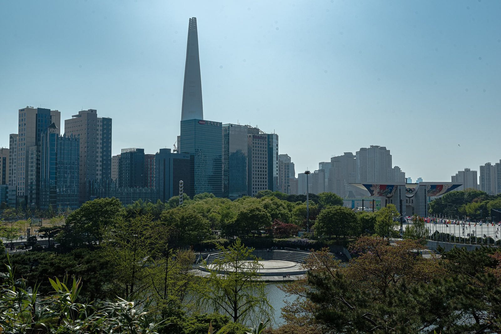 세계평화의 문 날개와 평화의 광장 깃발, 몽촌해자 너머로 보이는 롯데월드타워